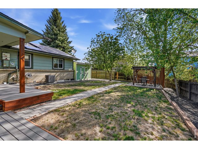 Property Photo 30 Private backyard oasis, complete with a Trex deck, pergola-covered patio, sprinkler system, and a concrete slab storage shed with electricity