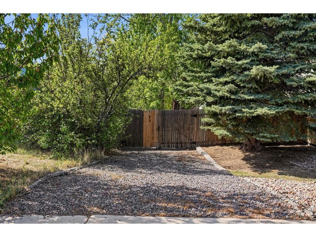 Property Photo 38 A side yard gravel driveway offers extra parking or storage for an RV or trailer, secured by a gate