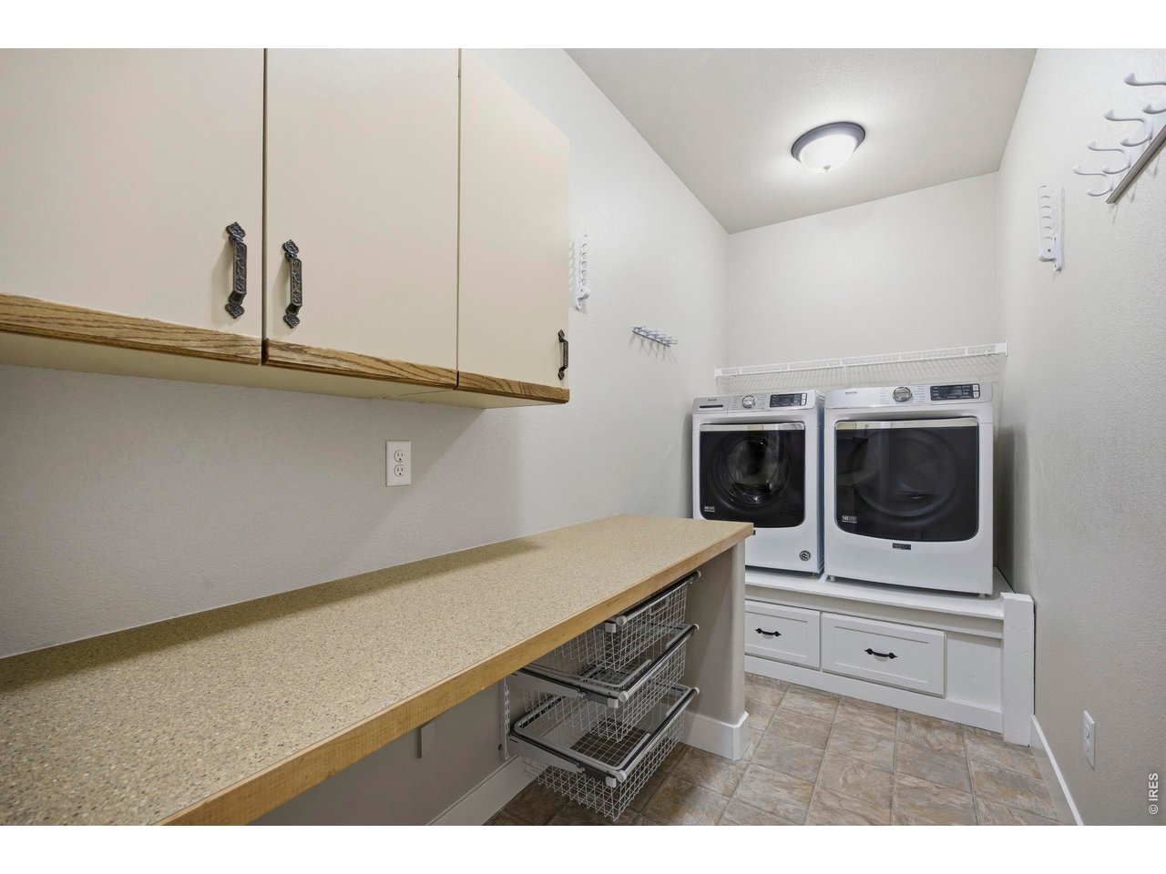Main Level Laundry Room with big Folding Table and under counter storage. Commercial Maytag White Washer & Dryer included
