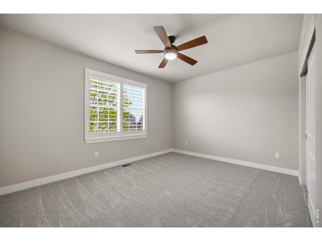 Property Photo 17 Bedroom 2 on Main Level with Custom Plantation Shutters and Ceiling Fan