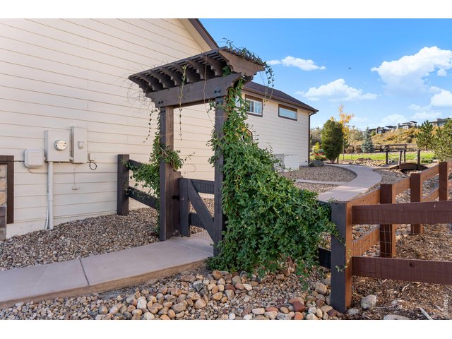 Property Photo 34 Custom Side Entry Pergola with Vine, New Concrete Sidewalk and Oversized Storage Pad. New 1,000 sq. ft. stamped Concrete Patio