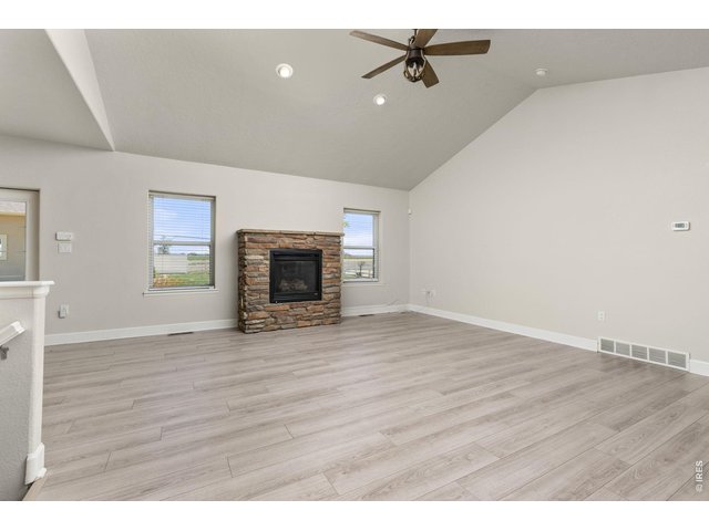 Property Photo 12 Inside, the ranch-style layout offers an open, vaulted living area with a gas fireplace, fully updated kitchen, and a main-level primary suite. 