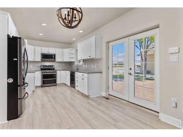 Property Photo 16 The kitchen has been updated with quartz countertops, subway tile backsplash, whitewash cabinetry, and newer appliances. 