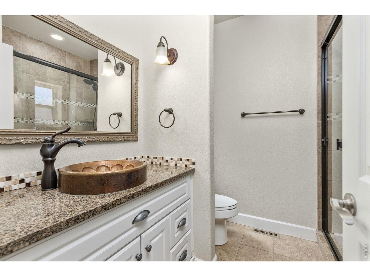 The primary suite has a fully updated bathroom with tile flooring, quartz countertops, and large tile shower.