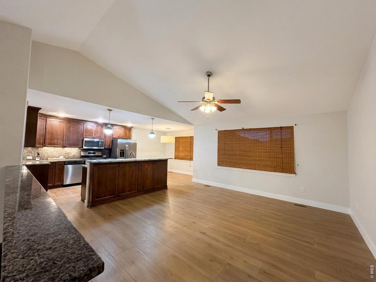 Property Photo 4 Open main floor living room have tiled floors, vaulted ceilings and a ceiling fan, huge window overlooks the backyard