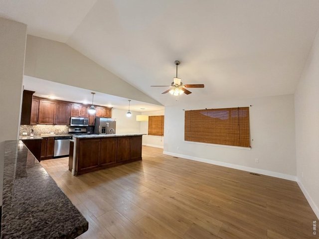 Property Photo 4 Open main floor living room have tiled floors, vaulted ceilings and a ceiling fan, huge window overlooks the backyard