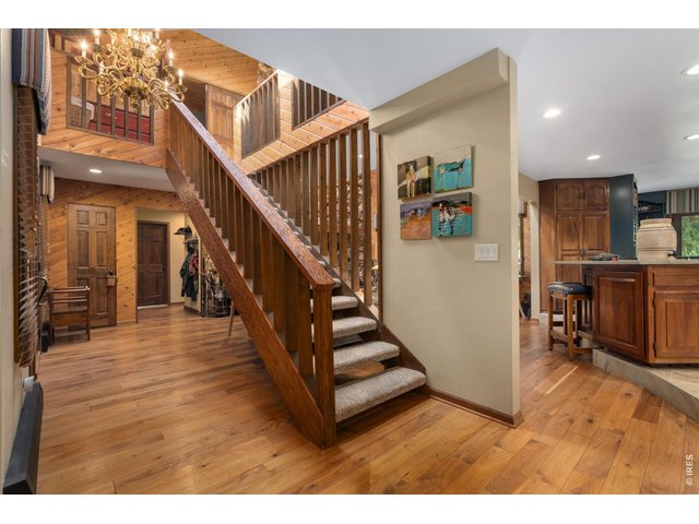 Property Photo 23 View of entry way and staircase to second level. Hand-scraped black walnut wood floors
