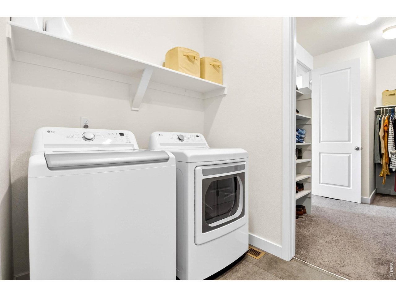 Laundry room conveniently located adjacent to walk-in closet of primary bedroom