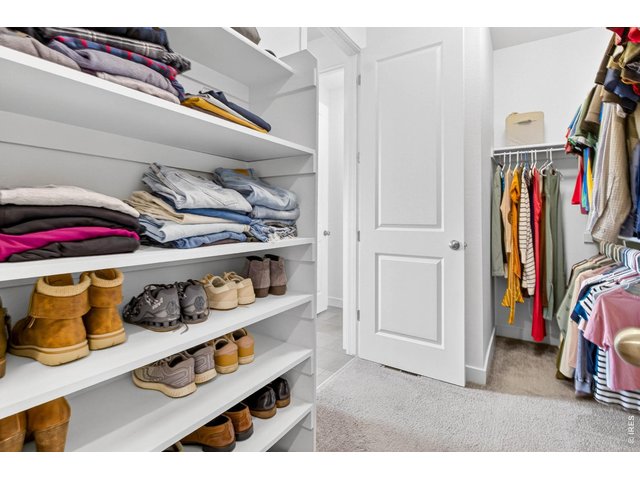 Property Photo 24 Walk-in closet, built out with shelving, shoe storage, and multi-level hanging rods.