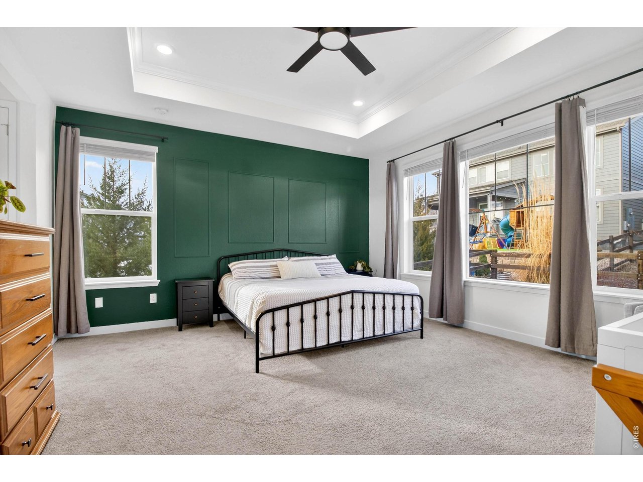 Primary bedroom with tray ceilings, recessed lighting, updated ceiling fan, and perfectly placed accent wall