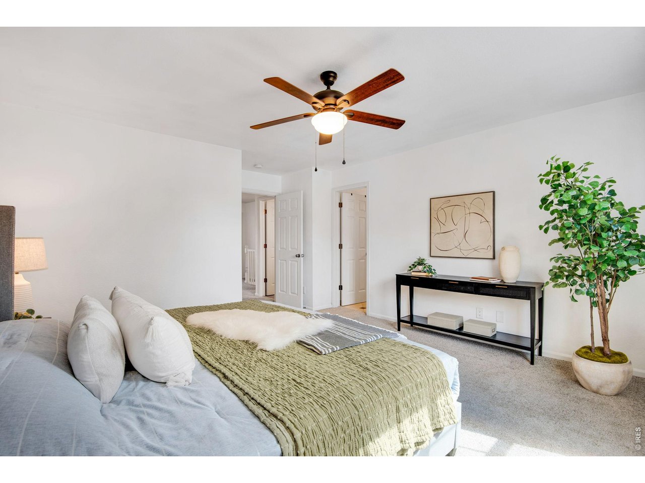 A primary suite sized for a real retreat - warm afternoon light, fresh carpet underfoot, and a ceiling fan that makes every evening feel effortless.