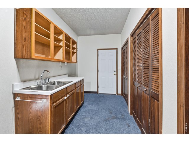 Property Photo 46 Large mudroom with utility sink, cabinetry, and storage.
