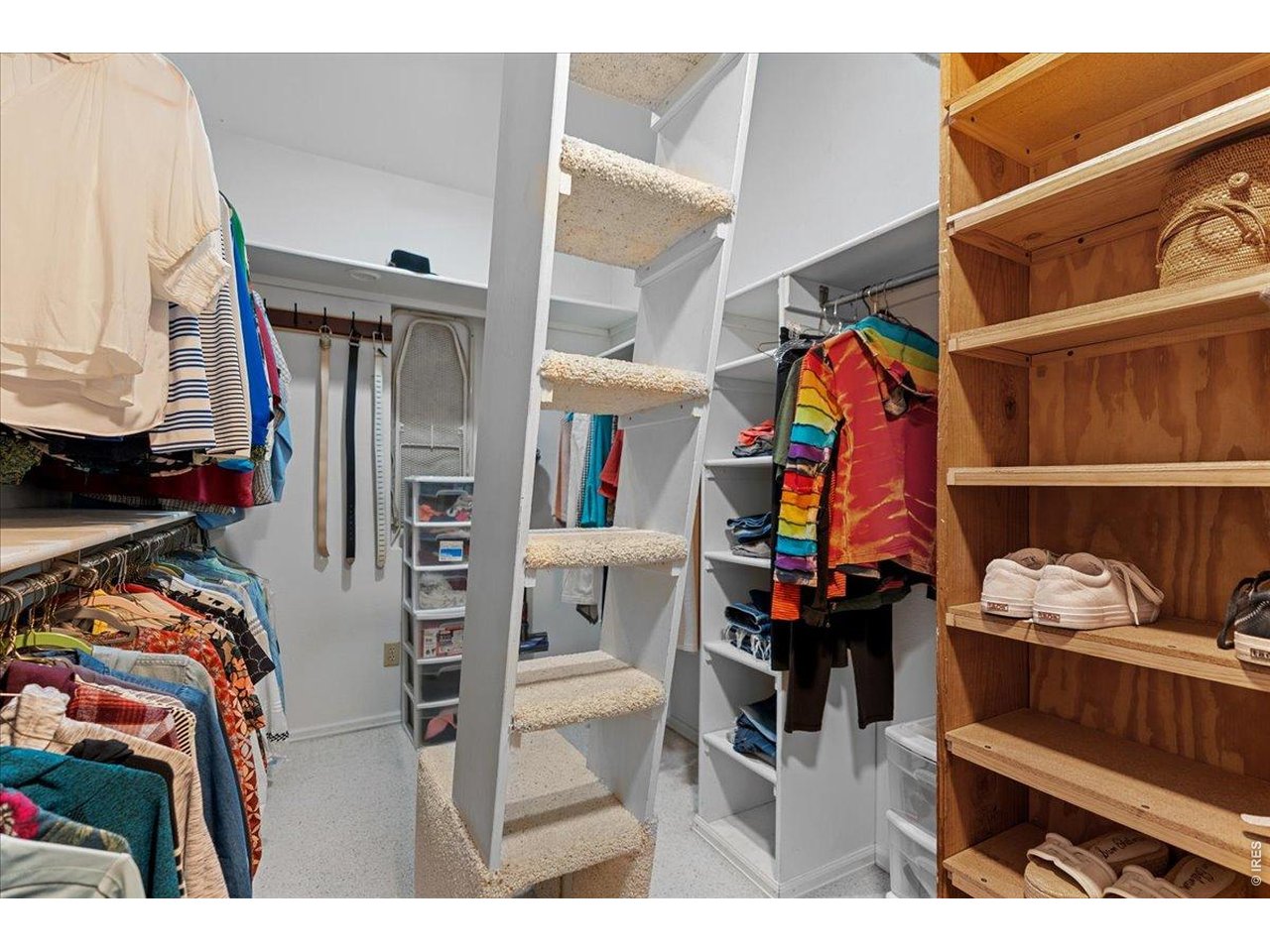 Large walk-in closet with built-in shelves and a loft for additional storage