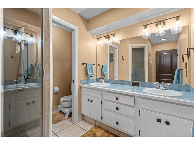 Property Photo 22 Large primary bathroom with dual vanity sinks and a large tiled shower. 
