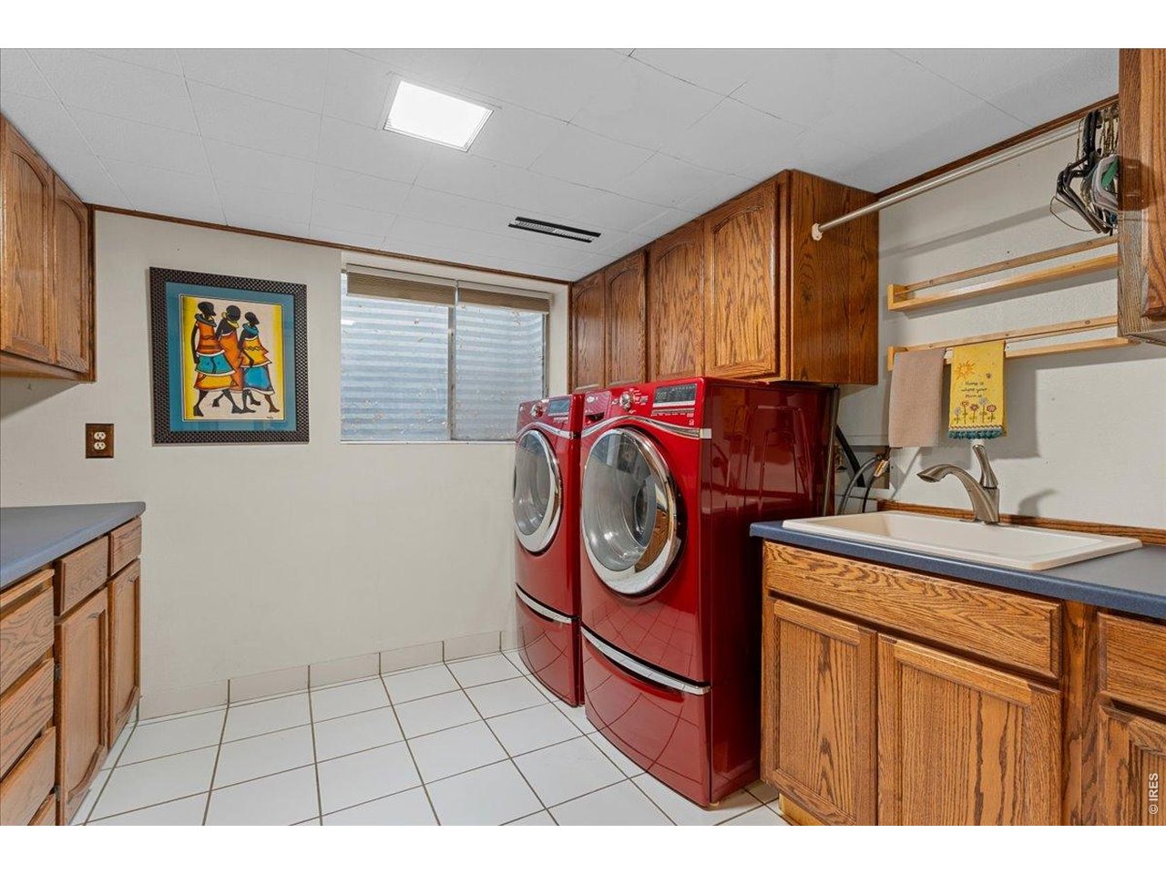 Basement laundry room, with large sink, storage cabinets, large washer, dryer and mini fridge (all included). 