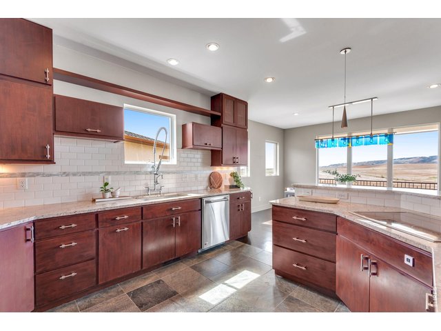Property Photo 24 Slab Granite, striking full height tile splash, commericial style faucet and integrated fridge. 