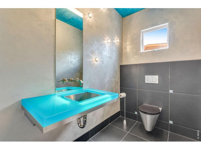 Property Photo 8 Artfully appointed Powder bathroom, all toilets are comfort height and dual flush! Check out this captivating glass sink - lit from within! 