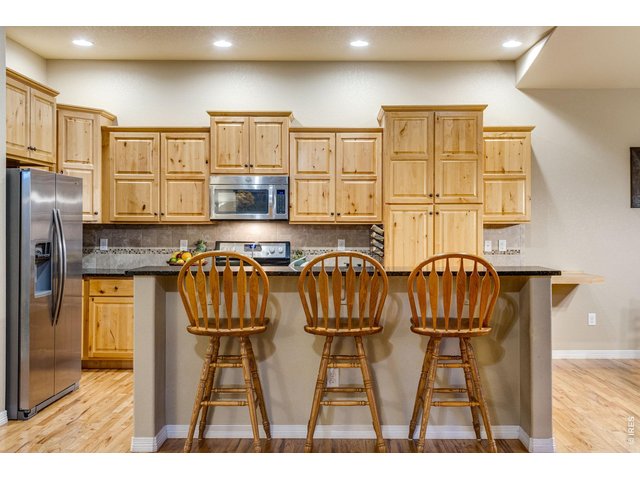 Property Photo 9 Center island, breakfast bar, pantry, granite slab countertops, cityscape knotty alder cabinetry with crown molding and hardware, full tile backsplash. 