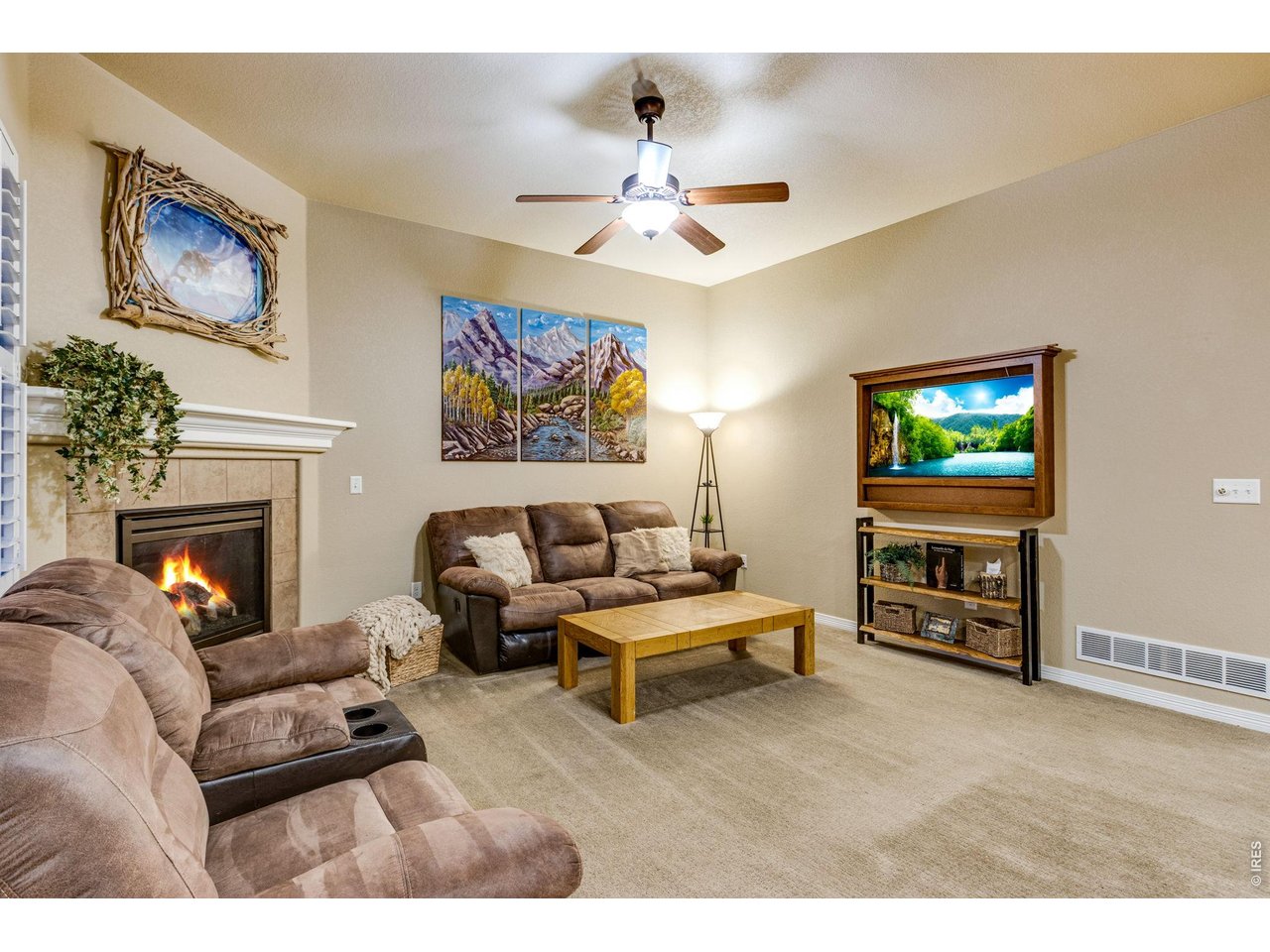 Living room with corner gas fireplace and a ceiling fan