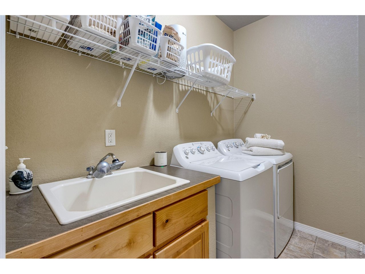 Laundry features a utility sink, hanging rod, and shelving. Washer and dryer are included 