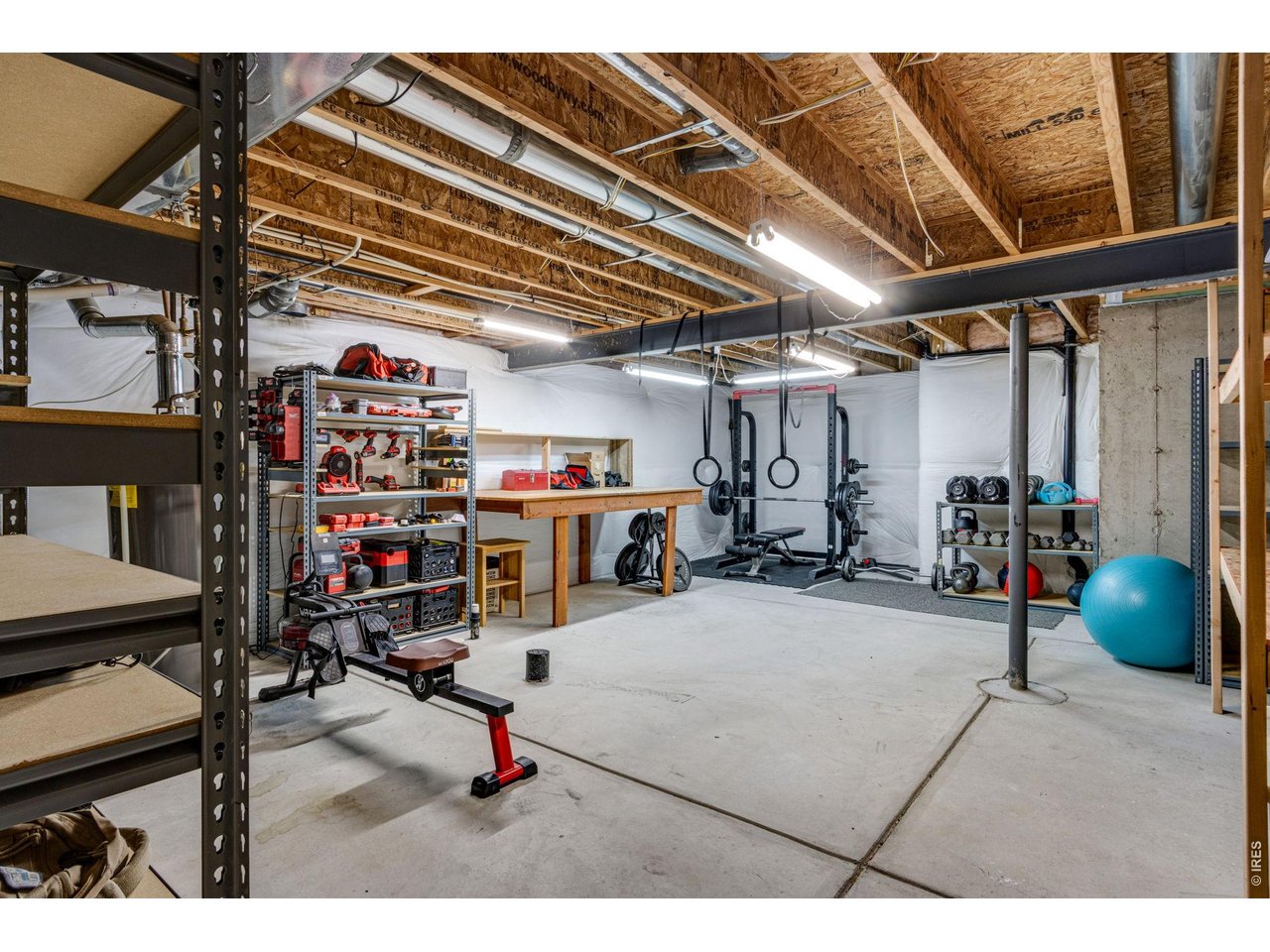 Large storage area is perfect for a shop, gym, craft room or extra storage. Attached shelving and work bench are included 