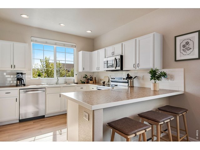 Property Photo 2 Bright and Luminous, the perfect eat-in kitchen with newly painted cabinetry, New full backsplash, stainless steel appliances. 