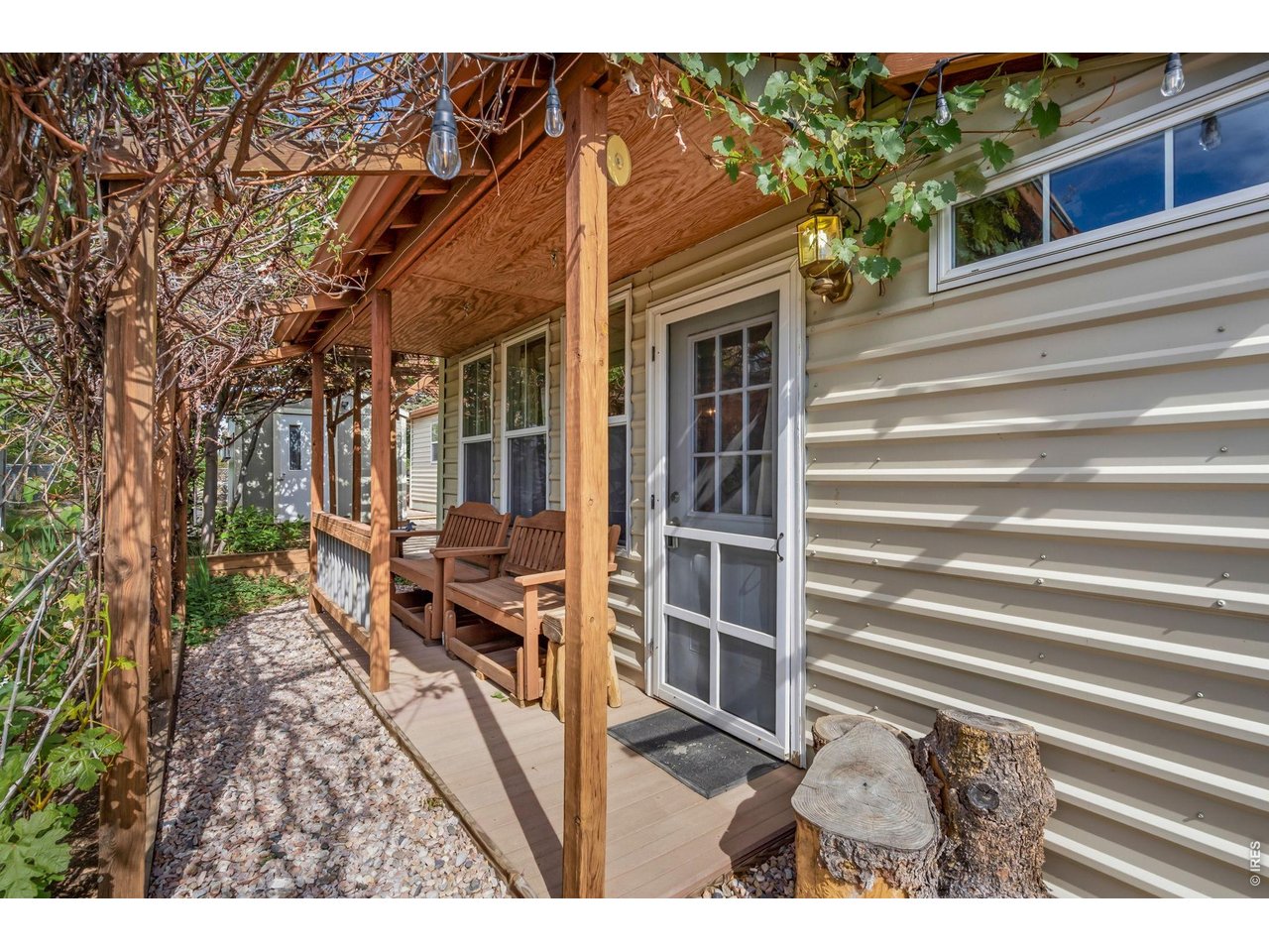 Front door main entry with covered porch and wooden benches.