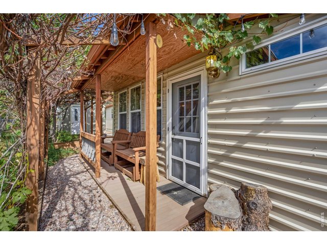 Property Photo 2 Front door main entry with covered porch and wooden benches.