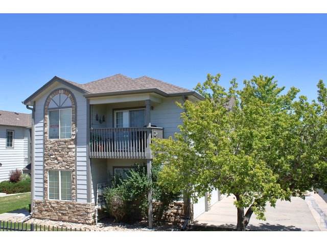 Property Photo 1 10371 Cook Way, 107, Thornton, Colorado. Balcony faces HOA open area with trees and pool.