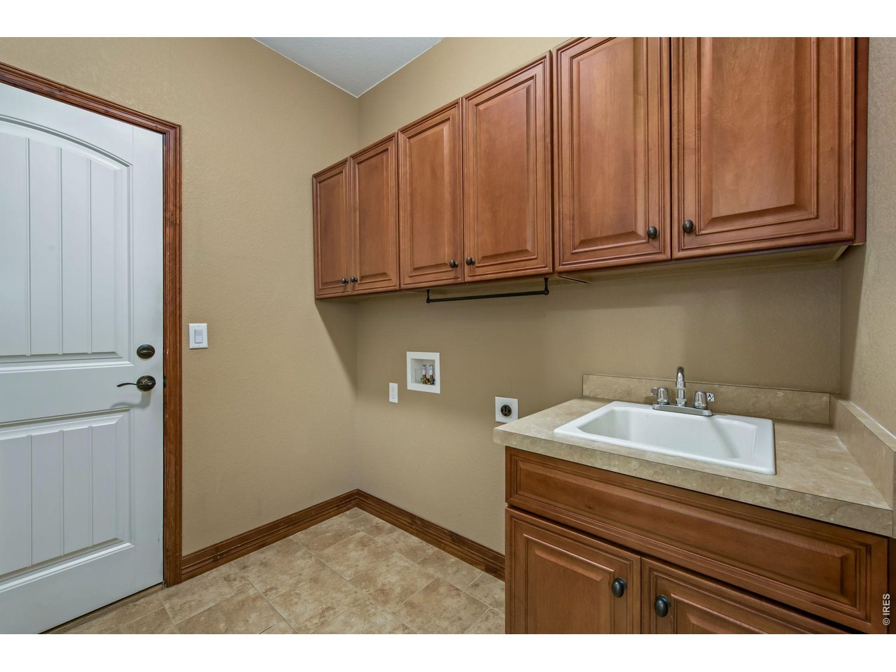Main floor laundry with utility sink and cabinets