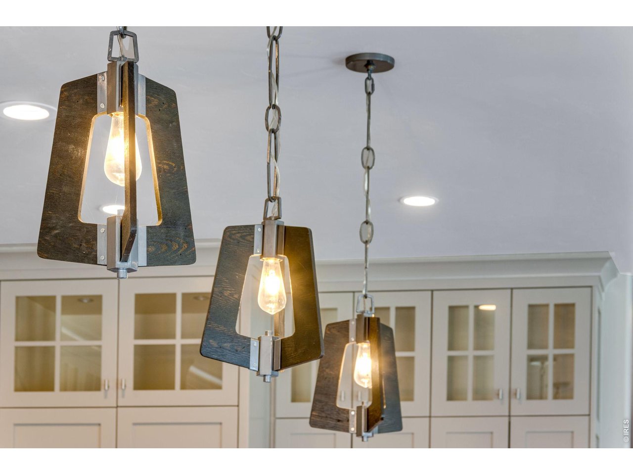 Stunning designer light fixtures and notice the glass doors and lighting in cabinets.