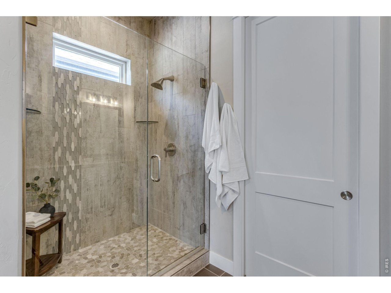 Primary shower featuring frameless glass, poured pan w/ floor to ceiling tile