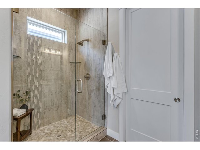 Property Photo 25 Primary shower featuring frameless glass, poured pan w/ floor to ceiling tile
