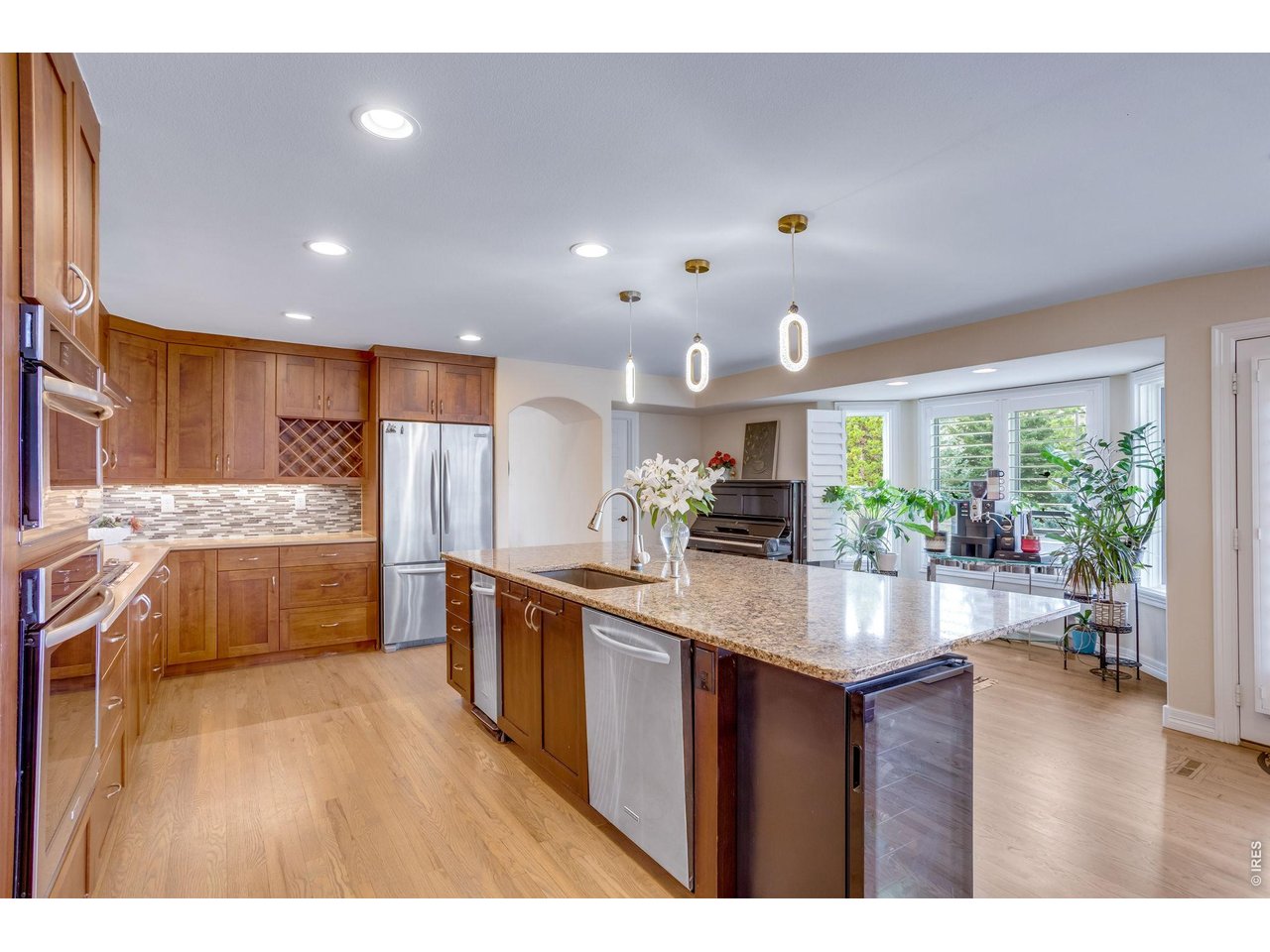 Huge slab granite island double wall ovens (top one converts to microwave), 5 burner gas cooktop, stainless appliances.