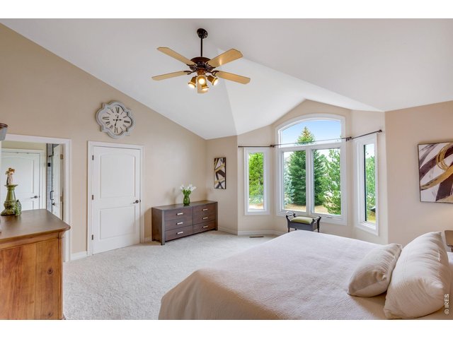 Property Photo 35 Upstairs, the private primary retreat offers a soothing escape, south side oversized bay window & vaulted ceiling.