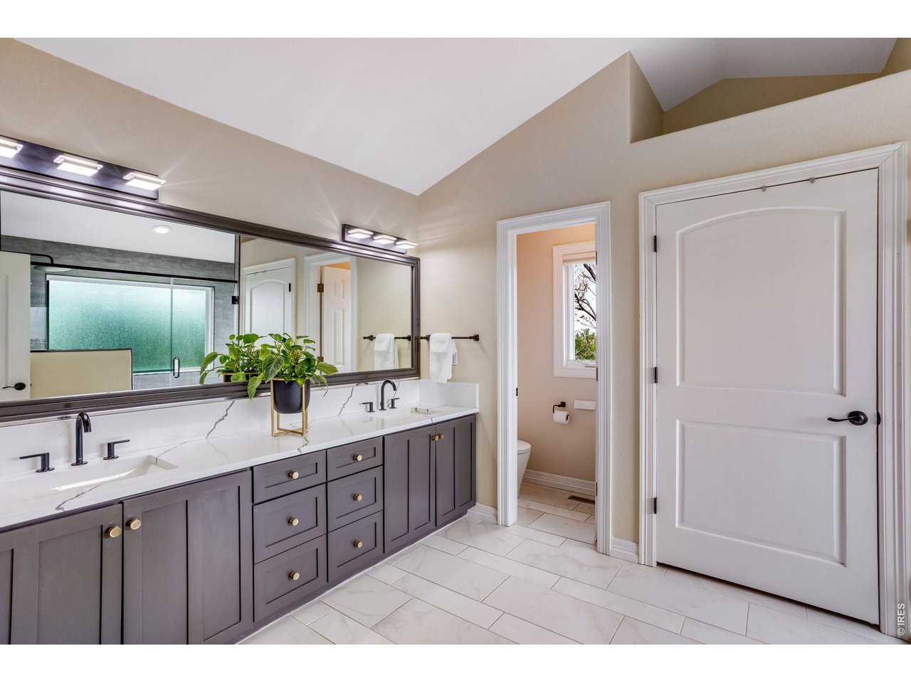 Upstairs, the private primary retreat is paired with a spa-inspired bath featuring heated flooring, creating a warm and luxurious start and finish to each day