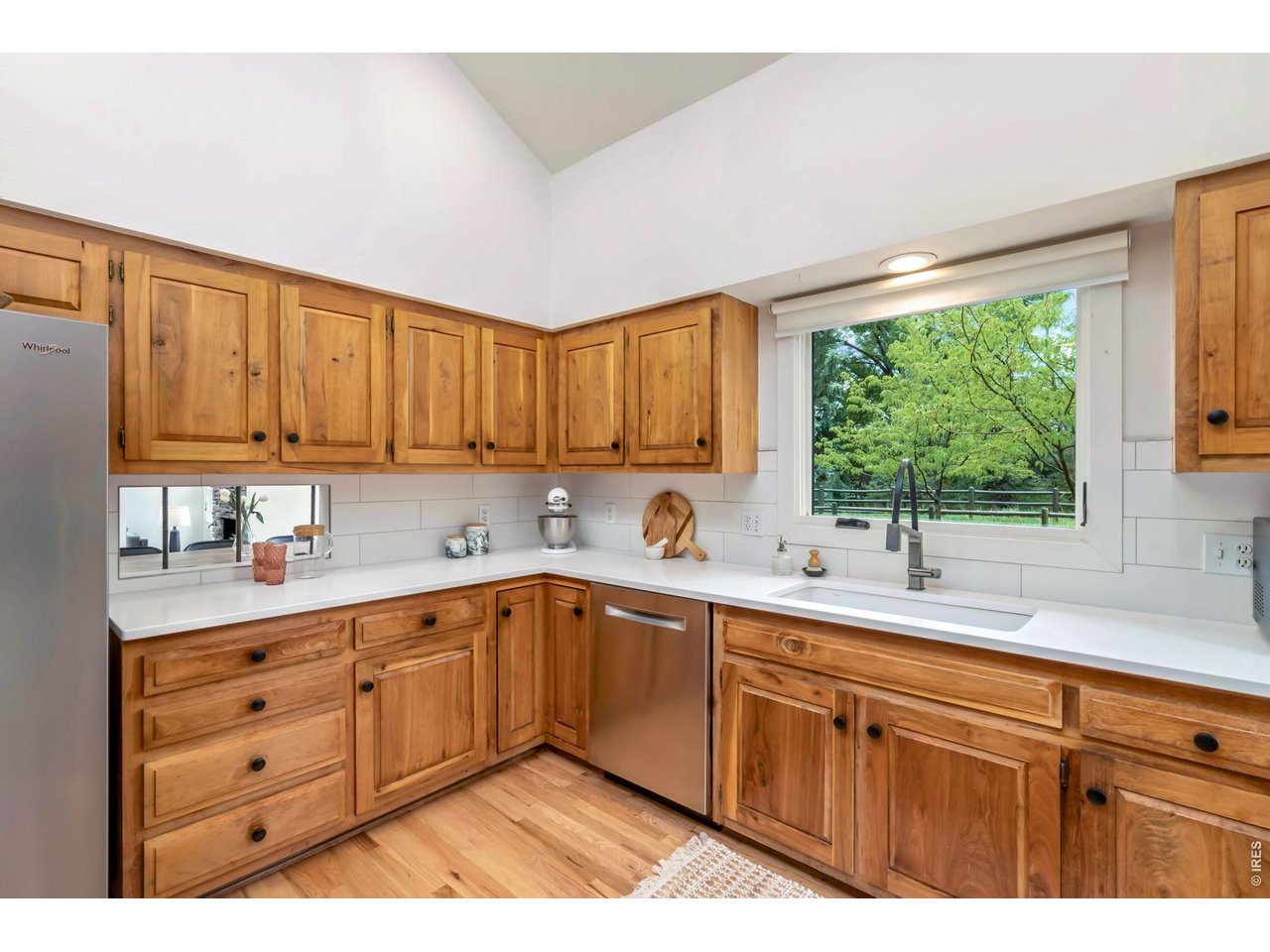 Beautifully updated chef's kitchen with updated cabinetry, drop-in sink, new subway tile backsplash, and new wood flooring. 