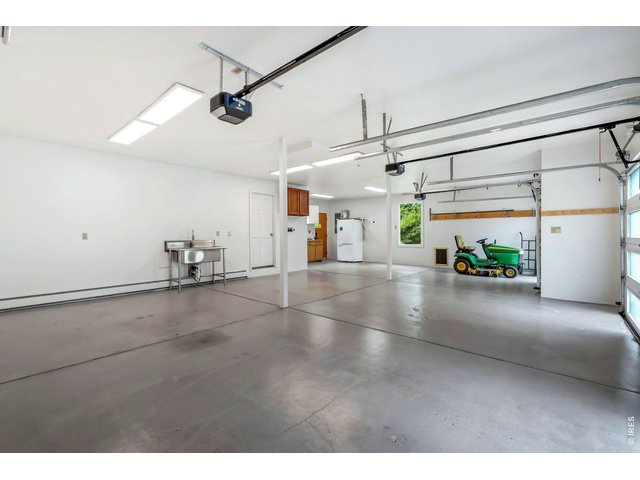 Property Photo 38 Oversized 3 car heated attached garage with newly refinished flooring, a wash station, and a dedicated work space. 