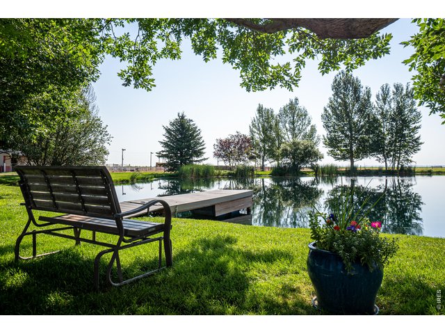 Property Photo 2 The park-like setting includes mature landscaping, sprinkler & drip systems, wood-burning fire-pit, horseshoe pits and large pond with dock