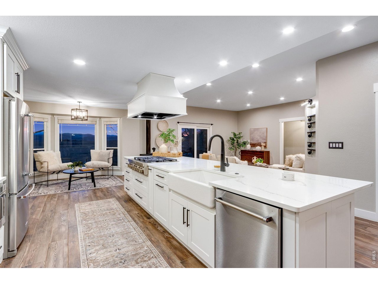 The chef's kitchen features a large island, quartz countertops, SS appliances, 6-burner gas range, commercial hood, double ovens, warming drawer & a walk-in pantry.
