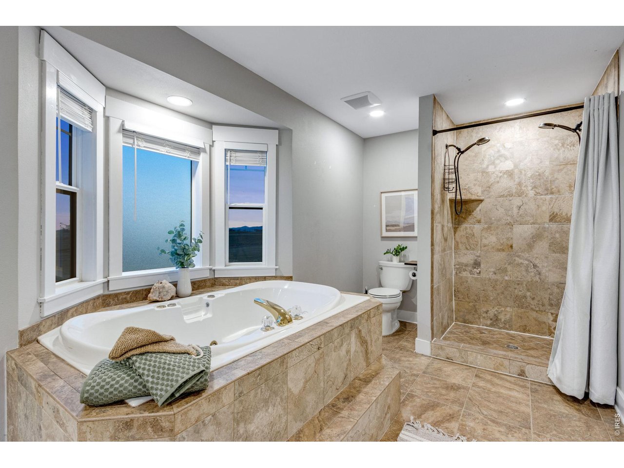 Primary bath features this jetted soaking tub and shower with 2 wands