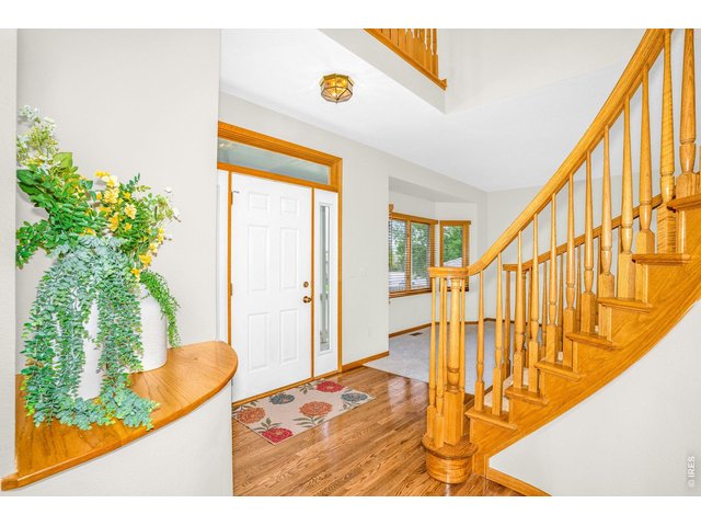 Property Photo 3 Enter the grand foyer with vaulted ceiling and beautiful wooden staircase leading to your second level. 
