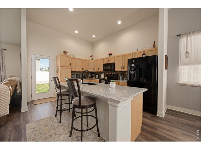 Property Photo 5 Dream Kitchen! White & Gray Quartz Countertops, Large Island Perfect for Entertaining! Vaulted Ceilings with Canned Lighting, Laminate Hardwoods throughout Much of Main Level