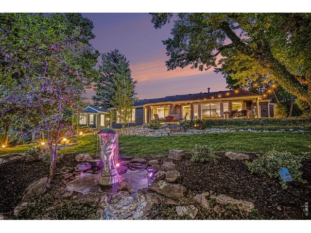 Property Photo 40 This spectacular dusk view highlights the custom water fountain feature, professional landscape lighting, and the warm, glowing presence of the main-level living spaces.