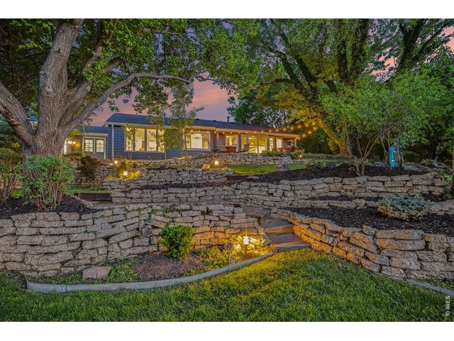 Property Photo 44 Dramatic twilight perspective highlights the impressive dry-stack stone retaining walls, beautifully illuminated by custom low-voltage path lighting and warm bistro strings along the ranch.