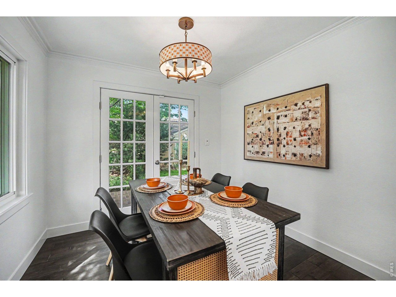 Formal dining space anchored by premium wood flooring. Classic French doors provide plenty of natural light and open to the wrap-around brick patio for morning coffee.