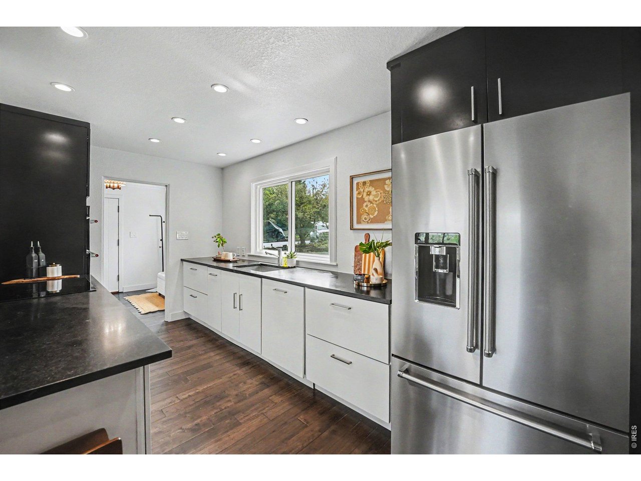 Fully remodeled kitchen workspace. Showcases high-end stainless steel appliances, contemporary flat-panel cabinets, recessed lighting, and beautiful granite countertops.