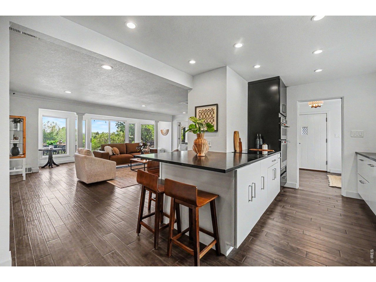 Stunning remodeled kitchen features a sleek breakfast bar island, modern contrast cabinetry, and updated appliances. The open layout keeps you connected to the living area and backyard views.
