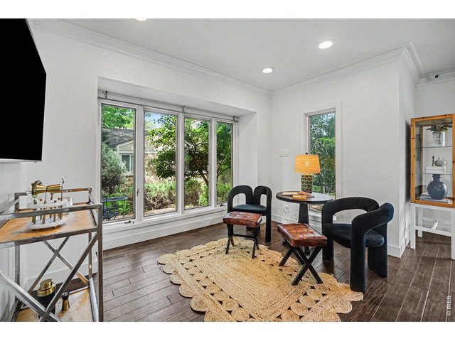 Property Photo 12 A charming, sun-drenched sitting nook off the main living area. The large windows flood the space with natural light and frame beautiful views of the side yard.