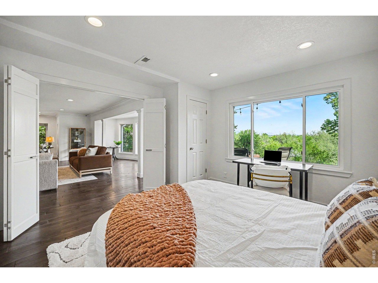 Elegant double doors open up this spacious bedroom directly to the main living area, creating a flexible layout that's perfect for a wide-open home office, an extended family room, or a private guest suite.